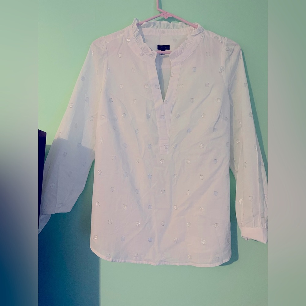 Hermosa blusa blanca con adornos plateados tiene en cuello un pliegue hermoso